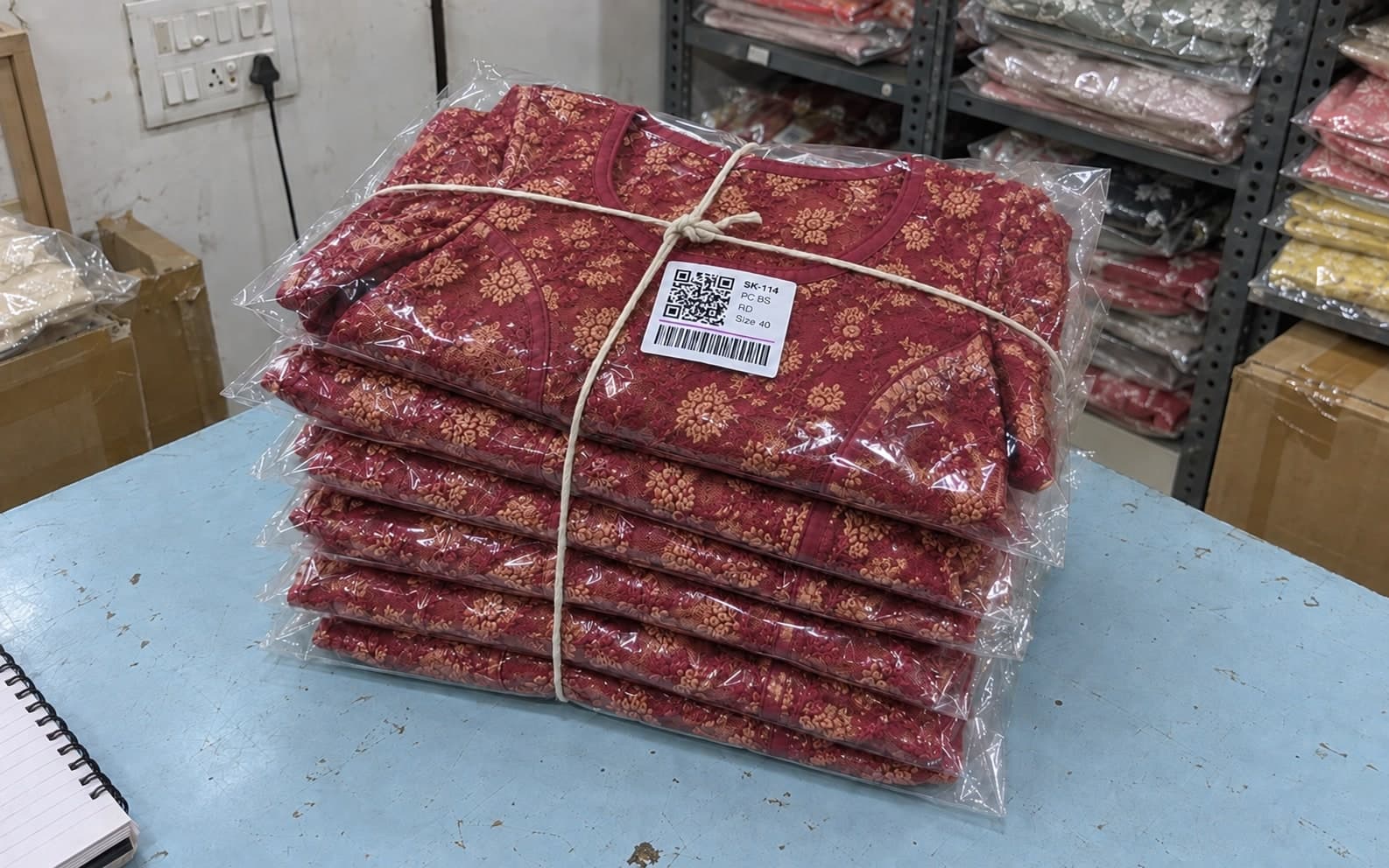 A PakkaStock label on a tied bundle of blouses