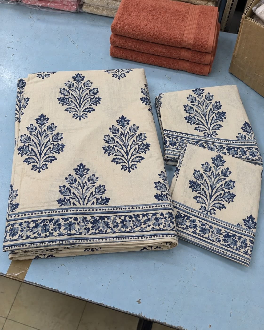 Folded patterned bed linen, pillow covers and terracotta towels
